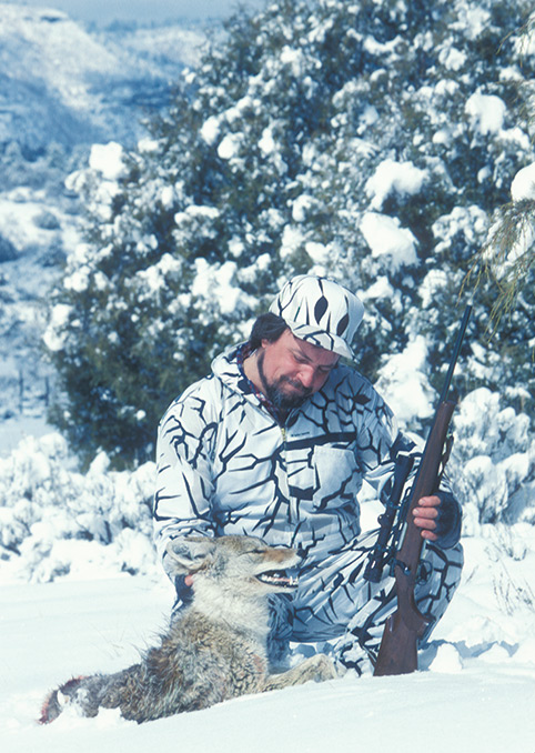 Hunter in white camo with coyote he killed